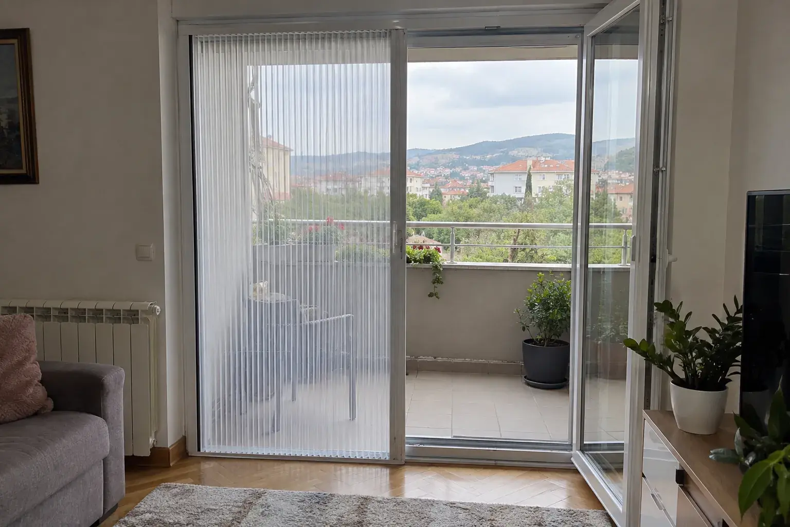 Plise komarnik napola razvučen preko balkonskih vrata
